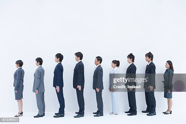 business people standing in a row, side view - whole ストックフォトと画像