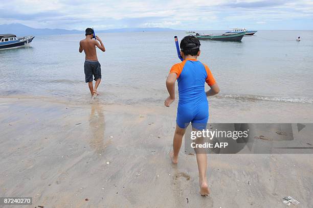 Local visitors enjoy the crystal clear waters of Bunaken Island, a snational marine park in North Sulawesi on May 14, 2009. The tiny island is a...