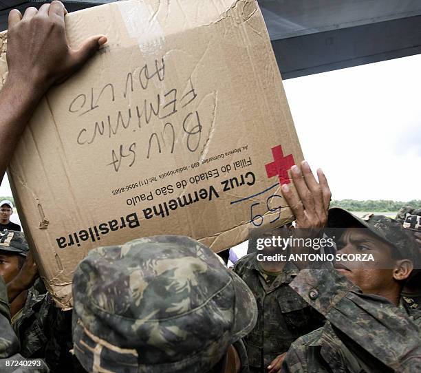 Brazilian Air Force personnel unload from a plane food, clothes and medicine from the Brazilian Red Cross for the victims of the floods, at the Sao...