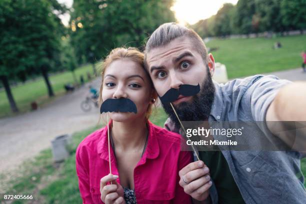 teenager paar machen selfies im park - movember stock-fotos und bilder