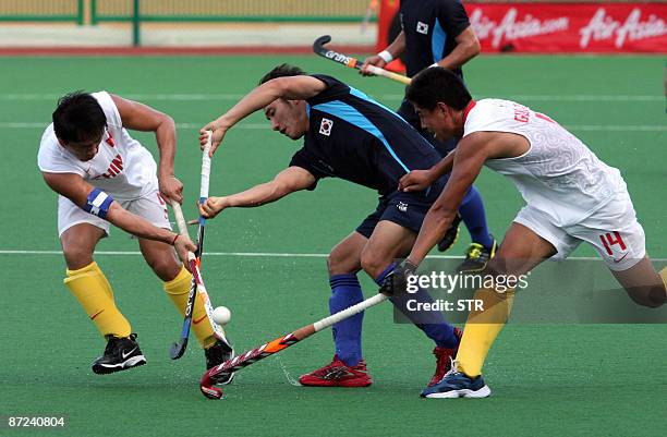 SOUTH Korea's Lee Nam Yong is tackled by China's Song Yi and Guo Zhong Qiang during their match at the Asia Cup field hockey tournament in Kuantan,...