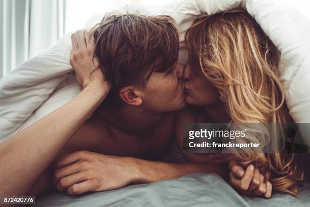 coppia baciarsi in camera da letto - attività sessuale umana foto e immagini stock