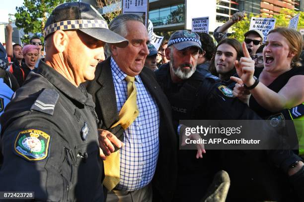 Protesters jostle people attending a Liberal Party fundraiser in Sydney on November 10 as they call on the ruling Liberal coalition government to...