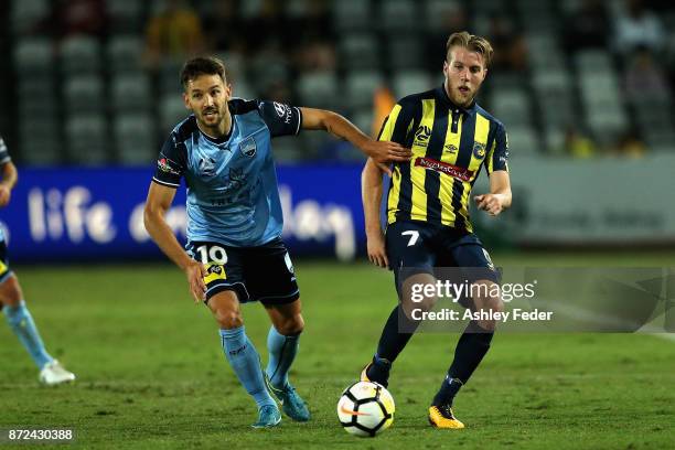 Andrew Hoole of the Mariners contests the ball against Milos Ninkovic of Sydney FC during the round six A-League match between the Central Coast...