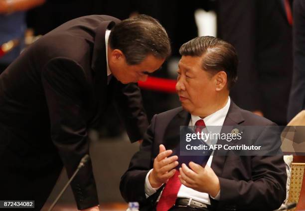 China's President Xi Jinping speaks to Foreign Minister Wang Yi during the APEC-ASEAN dialogue on the sidelines of the Asia-Pacific Economic...