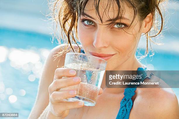brunette young woman holding a glass of water - seduzione foto e immagini stock