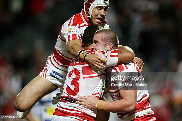 Jamie Soward, Neville Costigan and Justin Poore of the Dragons celebrate a try by Poore during the round 10 NRL match between the St George Illawarra...