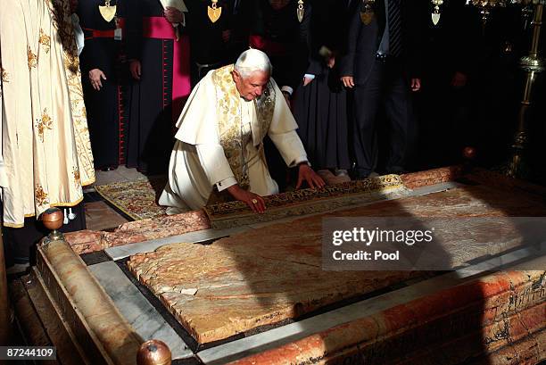 Pope Benedict XVI kneels in front of the Stone of Anointing, where Christians believe the body of Jesus was prepared for burial, in the Church of the...
