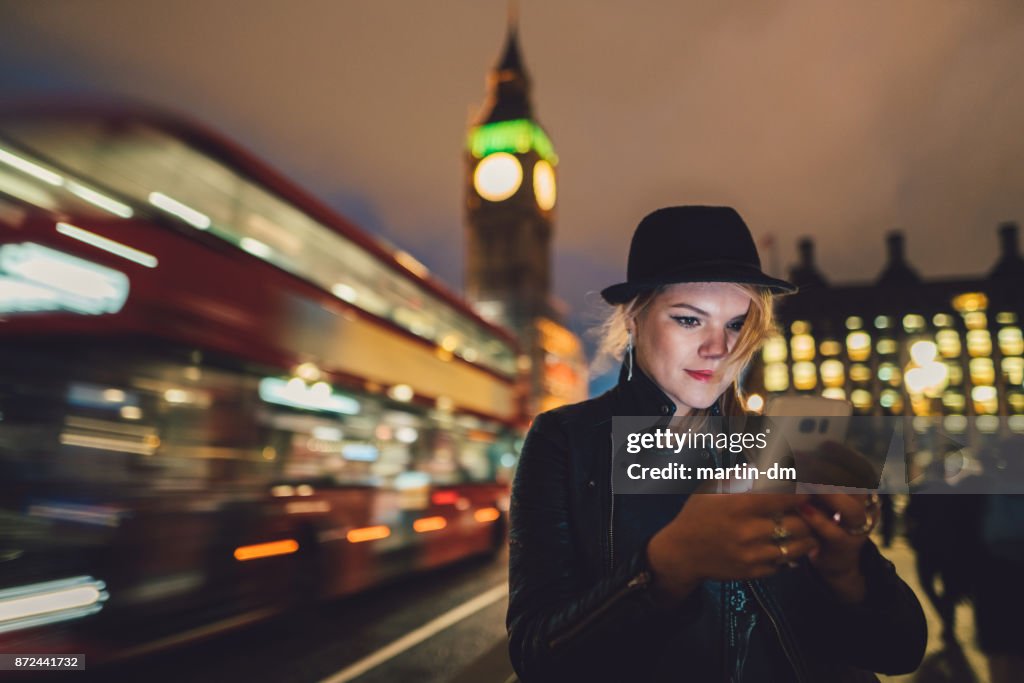 Teenage girl in London texting by night