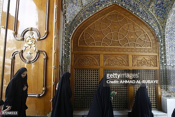 Iraqi Shiite Muslim worshippers walk through the decorated archway as they enter the Imam Musa al Kadhim mosque in the Kadhimiyah district of...