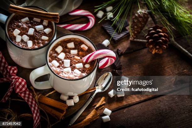 two homemade hot chocolate mugs with marshmallows on rustic wooden christmas table - christmas hot chocolate marshmallows stock pictures, royalty-free photos & images