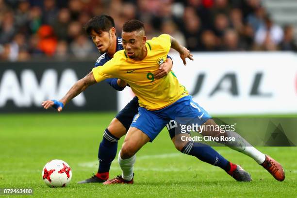 Hotaru Yamaguchi of Japan and Gabriel Jesus of Brazil battle for possession during the international friendly match between Brazil and Japan at Stade...