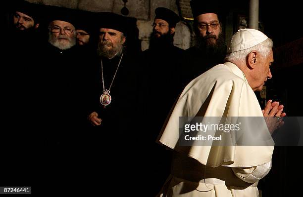 Greek Orthodox Priests watch as Pope Benedict XVI prays in the Golgotha, or Calvary, the traditional site where Jesus was crucified, in the Church of...