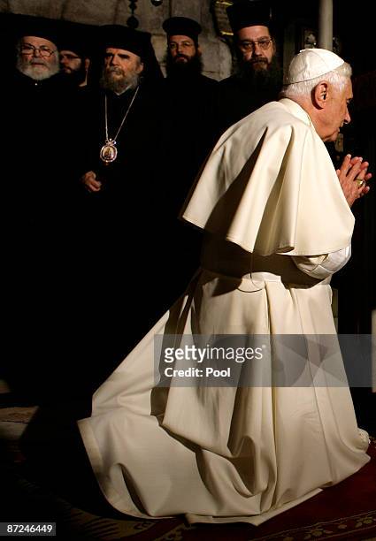 Greek Orthodox Priests watch as Pope Benedict XVI prays in the Golgotha, or Calvary, the traditional site where Jesus was crucified, in the Church of...