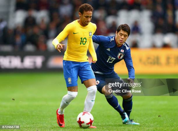 Neymar Jr of Brazil and Hiroki Sakai of Japan battle for possession during the international friendly match between Brazil and Japan at Stade...