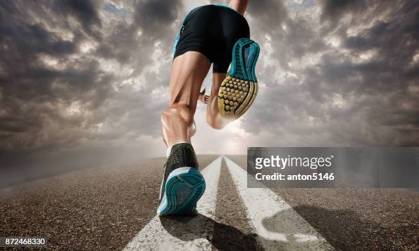 the close up feet of man running and training on running track - running stock pictures, royalty-free photos & images
