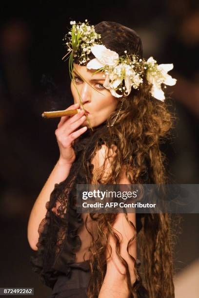 Una modelo fuma un habano durante el desfile de la colección del diseñador Montesinos Alama, en Madrid, el 19 de Febrero de 2001. / AFP PHOTO /...