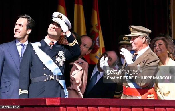 Le roi Juan Carlos d'Espagne plaisante alors que les membres de la famille royale regardent passer des avions, le 12 octobre 2000 à Madrid, lors du...