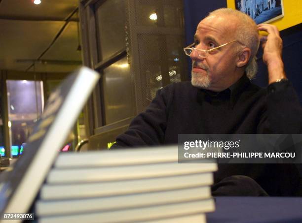 Brazilain author Paulo Coelho autographs 08 February 2001 copies of his newly-released book "El demonio y la senorita Prym" at a book-signing...