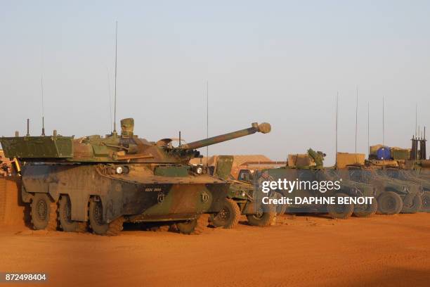 Soldiers of France's Barkhane mission stand next military vehicles on the military base in Gao on October 31, 2017 as a joint anti-jihadist force...
