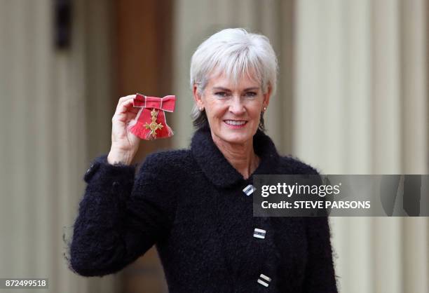Judy Murray poses with her medal after she was awarded an Officer of the Order of the British Empire for services to tennis, women in sport and...