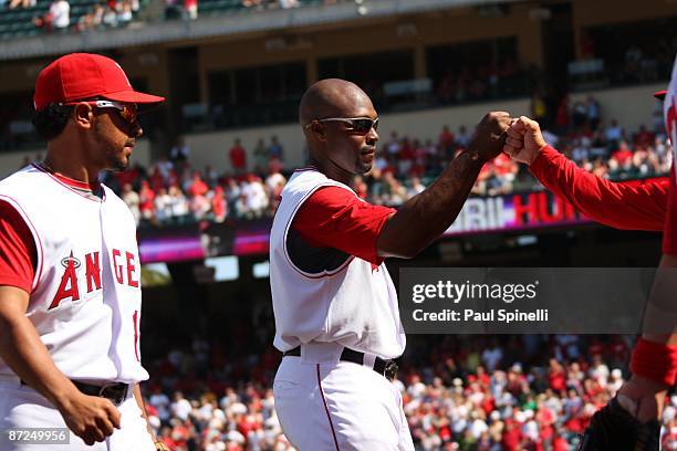 Torii Hunter of the Los Angeles Angels of Anaheim gets a fist bump from teammates after making a great catch during the game against the Boston Red...