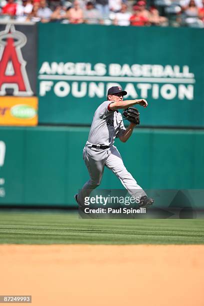 Right fielder J.D. Drew of the Boston Red Sox catches a fly ball by Torii Hunter of the Los Angeles Angels of Anaheim while throwing to home plate to...