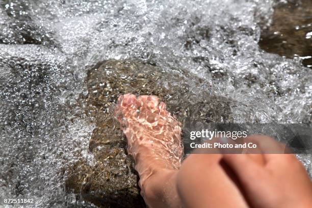 boy feet on stone in water - ankle deep in water fotografías e imágenes de stock