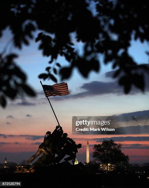 The early morning sun begins to rise behind the US Marine Corps Iwo Jima Memorial on the Corps 242nd birthday on November 10, 2017 in Arlington,...