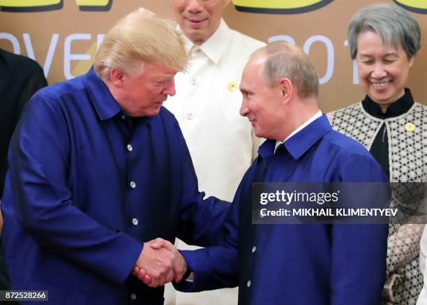 President Donald Trump shakes hands with Russia's President Vladimir Putin as they pose for a group photo ahead of the Asia-Pacific Economic...