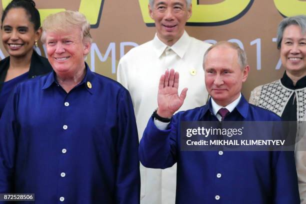 President Donald Trump and Russia's President Vladimir Putin pose for a group photo ahead of the Asia-Pacific Economic Cooperation Summit leaders...