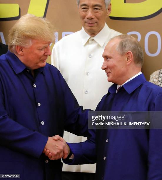 President Donald Trump shakes hands with Russia's President Vladimir Putin as they pose for a group photo ahead of the Asia-Pacific Economic...