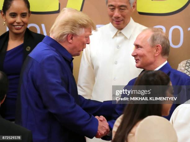 President Donald Trump shakes hands with Russia's President Vladimir Putin as they pose for a group photo ahead of the Asia-Pacific Economic...