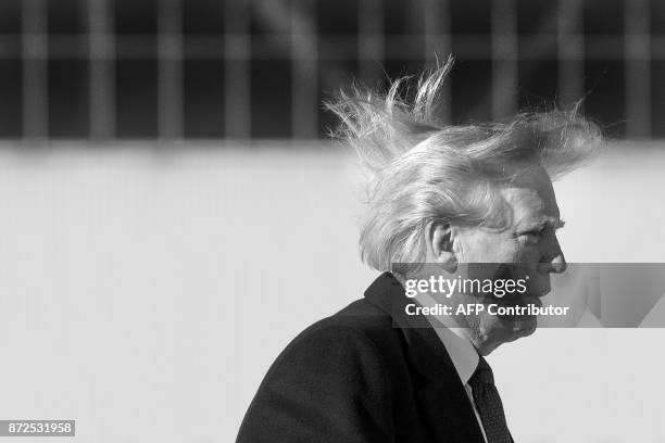 President Donald Trump's hair blows in the wind as he boards Air Force One before flying to Vietnam to attend the annual Asia Pacific Economic...