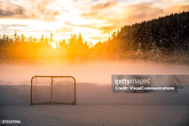 empty hockey net on frozen lake. - outdoor ice hockey stock pictures, royalty-free photos & images