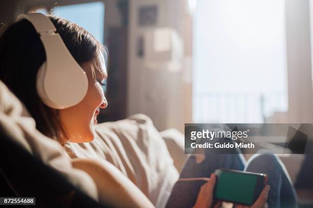 woman looking at smartphone. - entertainment music imagens e fotografias de stock
