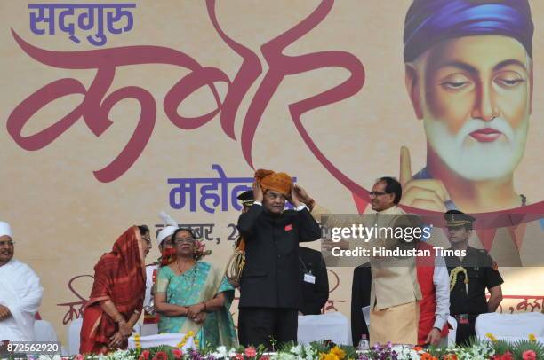 Madhya Pradesh Chief Minister Shivraj Singh Chouhan offering turban to President Ram Nath Kovind during Kabir Mahotsav on November 10, 2017 in...