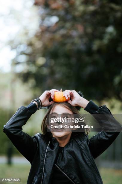 girl in a cat's costume at halloween with a pumpkin - cat costume stock pictures, royalty-free photos & images