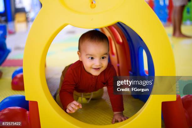 bambino che gioca in un tubo del tunnel - camminare a gattoni foto e immagini stock