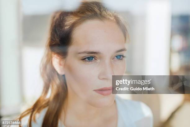 woman looking serious behind a window. - le monde naturel photos et images de collection