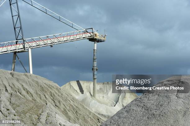 lithium ore falls from a chute onto a stockpile - mijnindustrie stockfoto's en -beelden