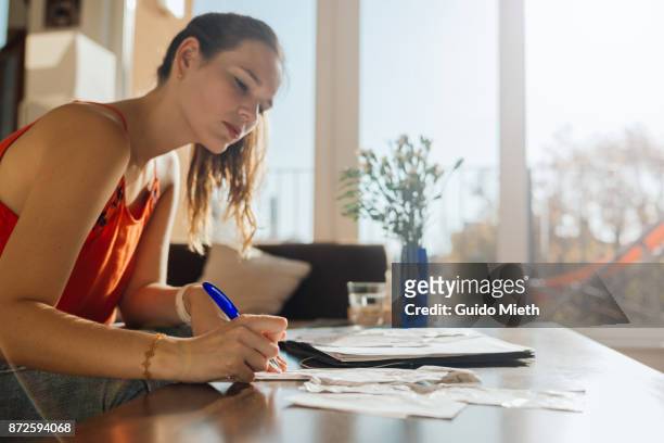 woman doing bookkeeping at home. - finanzen stock-fotos und bilder