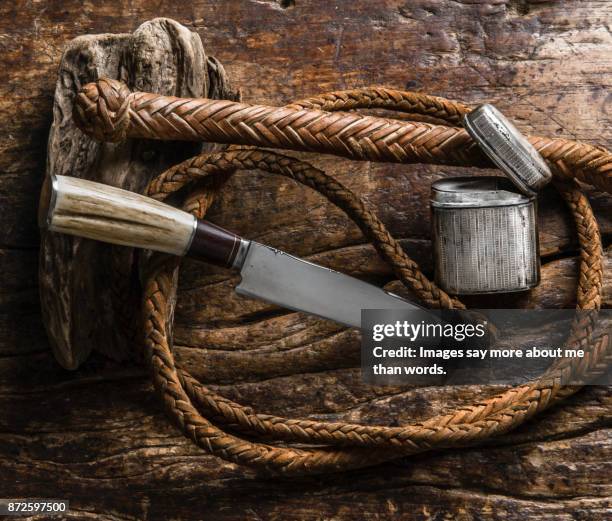 gaucho knife, whip, silver cigarette case on wood. still life - animal macho stockfoto's en -beelden