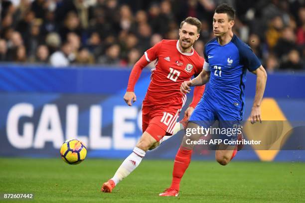 Wales' midfielder Aaron Ramsey vies for the ball with France's defender Laurent Koscielny during the friendly football match between France and Wales...