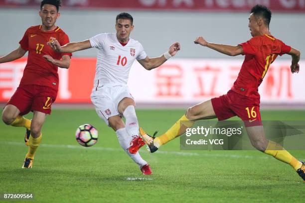 Li Xuepeng of China and Dusan Tadic of Serbia compete for the ball during International Friendly Football Match between China and Serbia at Tianhe...