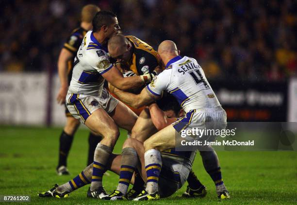 Chris Feather of Castleford Tigers is tackled by Ryan Hall and Keith Senior of Leeds Rhinos during the Engage Super League match between Castleford...