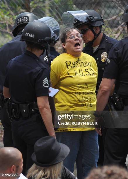 Teacher chants slogans as she is arrested during a protest against budget cuts which would increase class sizes outside the Los Angeles Unified...