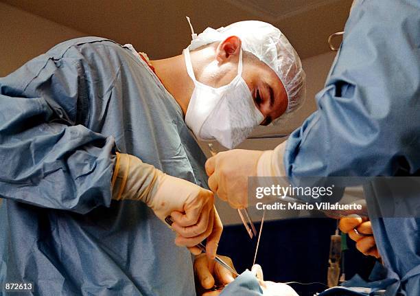 Dr. Jason Lustig, DDS, MD, conducts the first of two surgeries during a 14 hour hospital day June 26, 2002 at Louisiana State University Health...