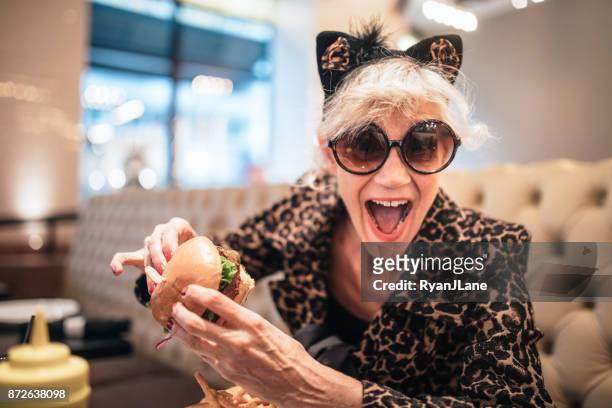 stijlvolle en eigenzinnige senior vrouw in restaurant - offbeat stockfoto's en -beelden