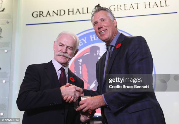 Chairman of the Hockey Hall of Fame Lanny McDonald presents Dave Andreychuk with the Hall ring during a media opportunity at the Hockey Hall Of Fame...